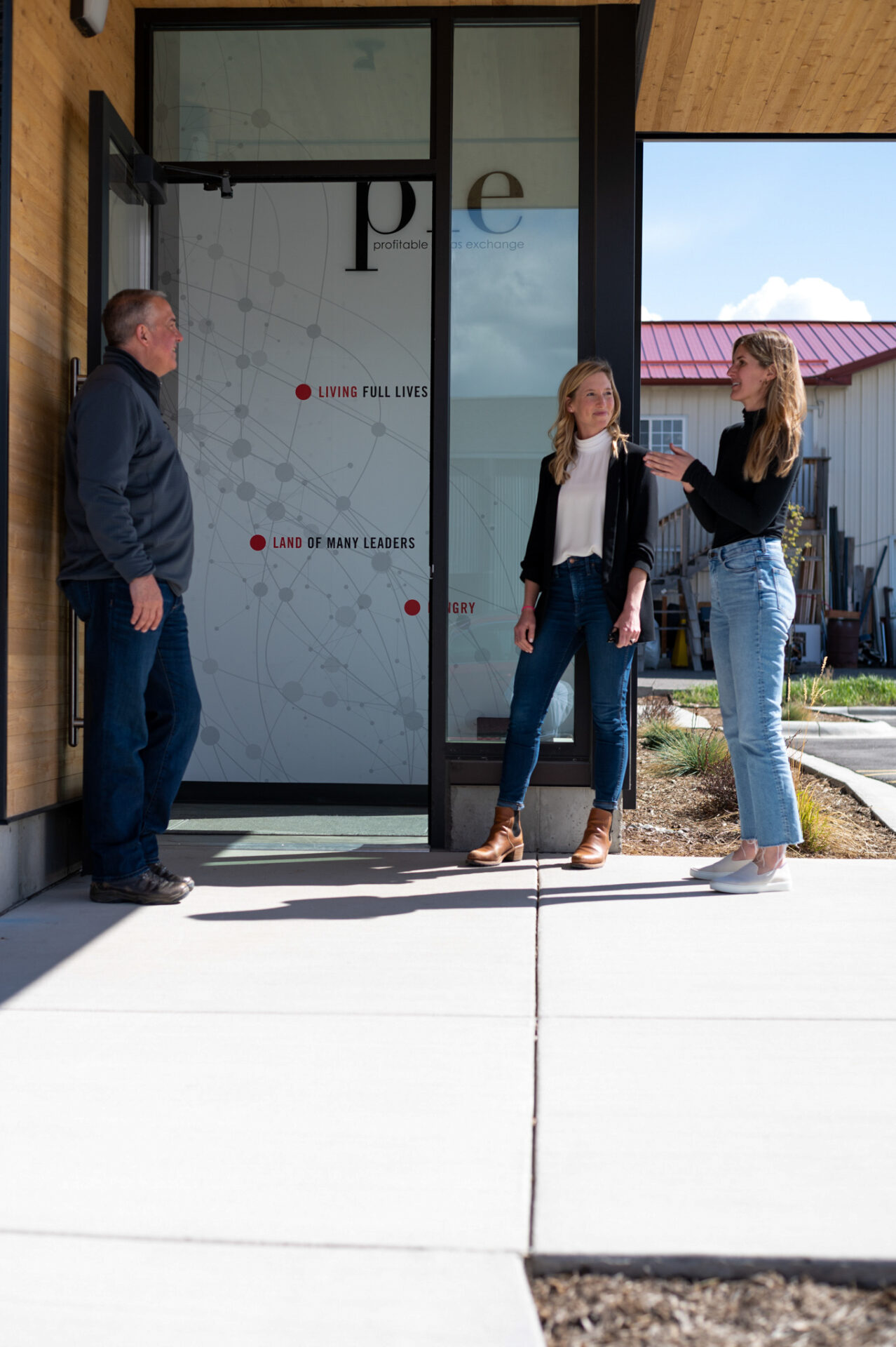 Tom McMakin, Erika Flower, and Andi Baldwin standing outside PIE headquarters
