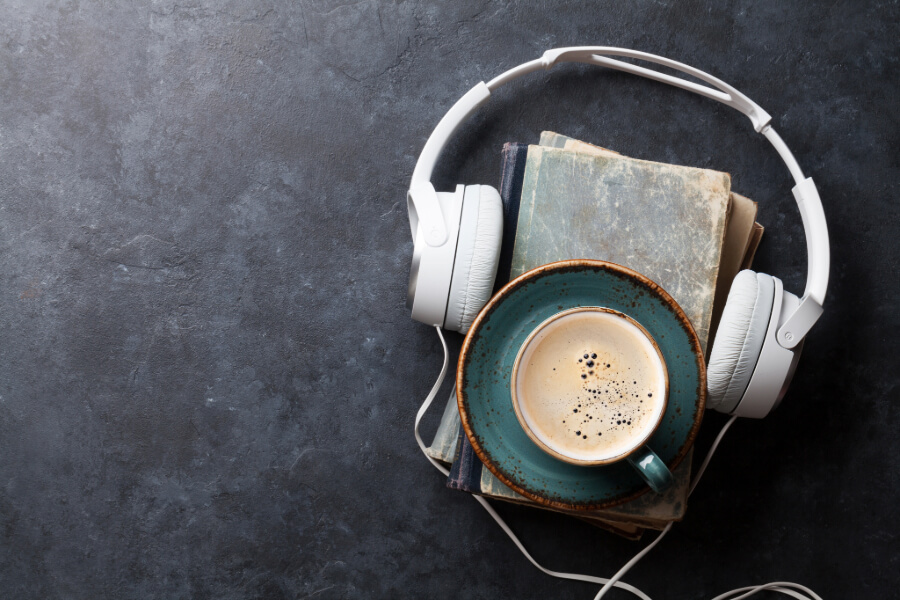 a headset on a table with books and a cup of coffee